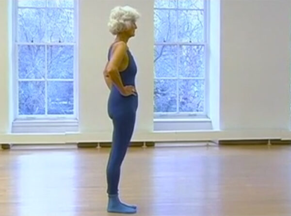 A woman in blue is standing on one leg