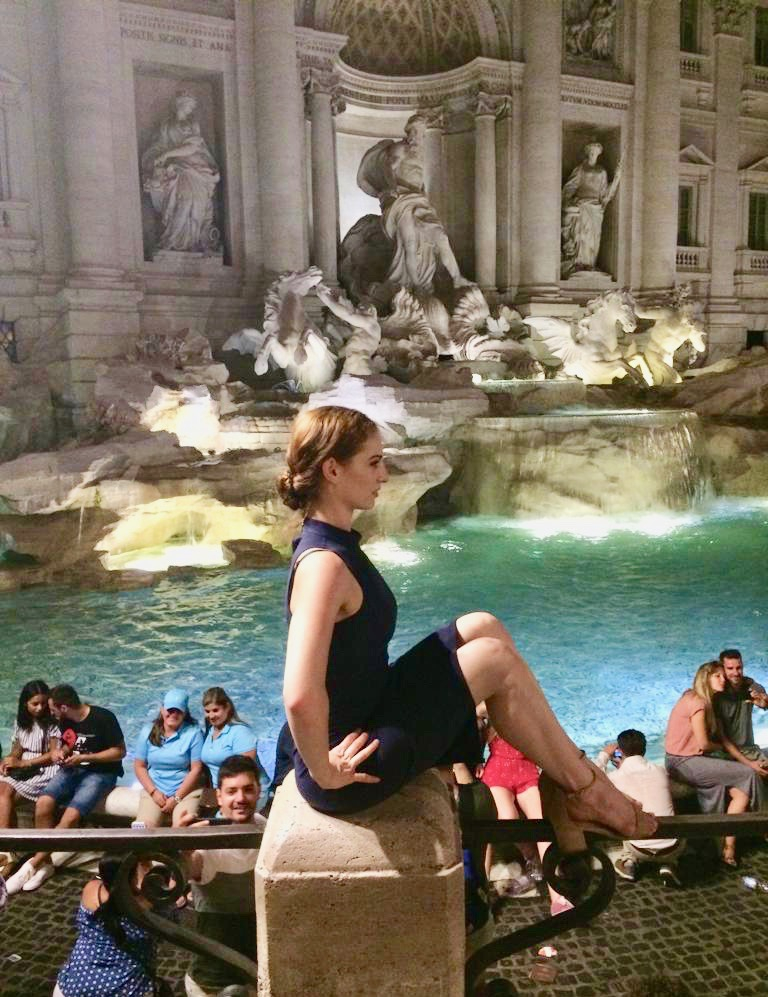a woman doing the floor-barre exercise near the trevi fountain
