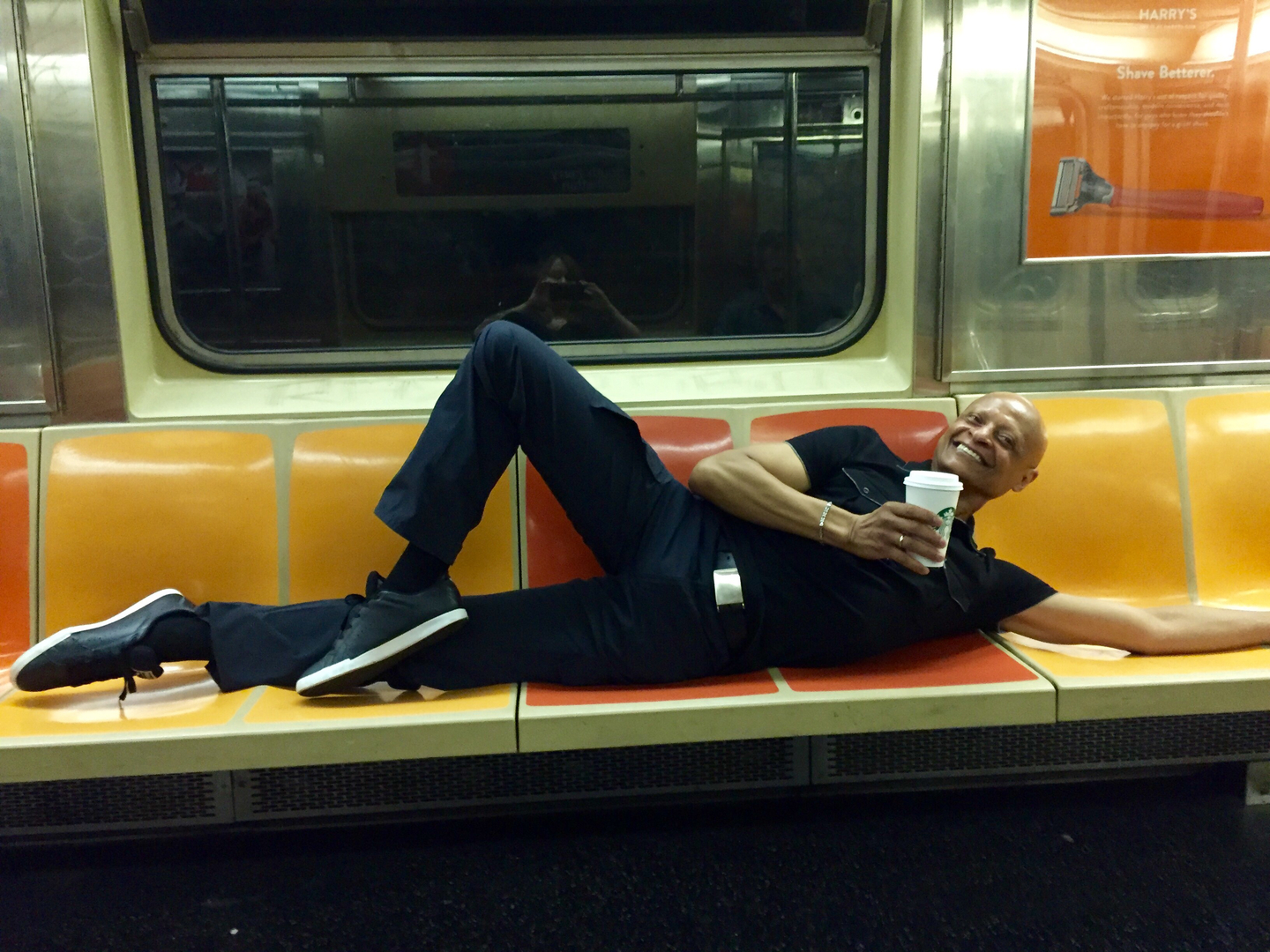 a man doing a floor-barre pose inside a train