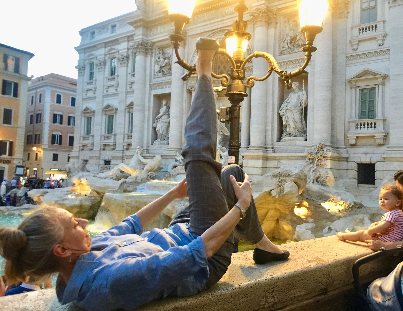 a woman doing the floor-barre exercise near the trevi fountain