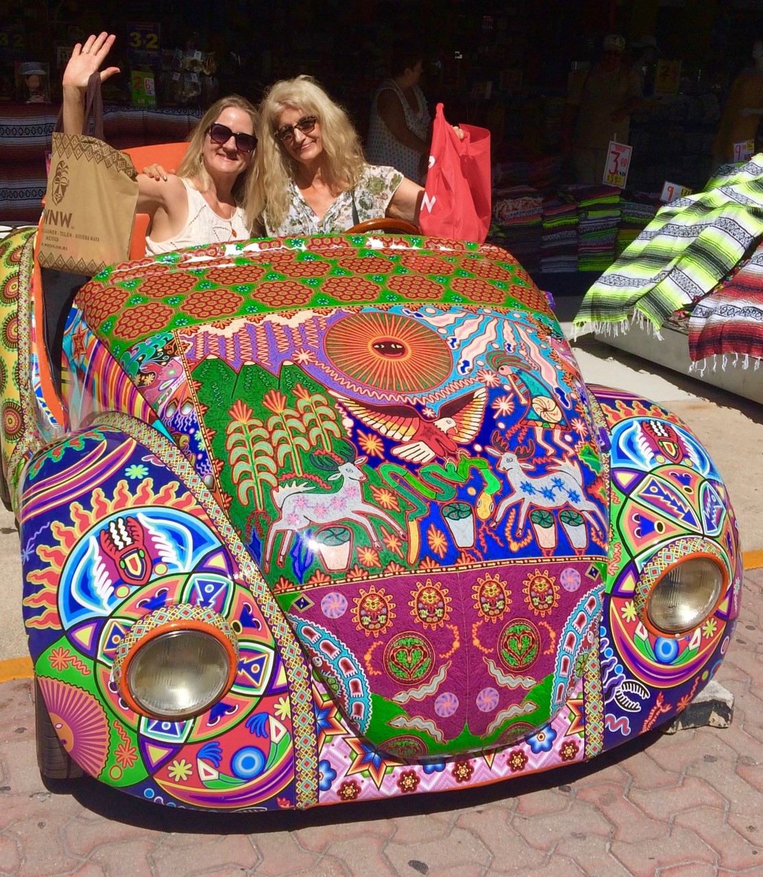 two women sitting in a colorfully painted car