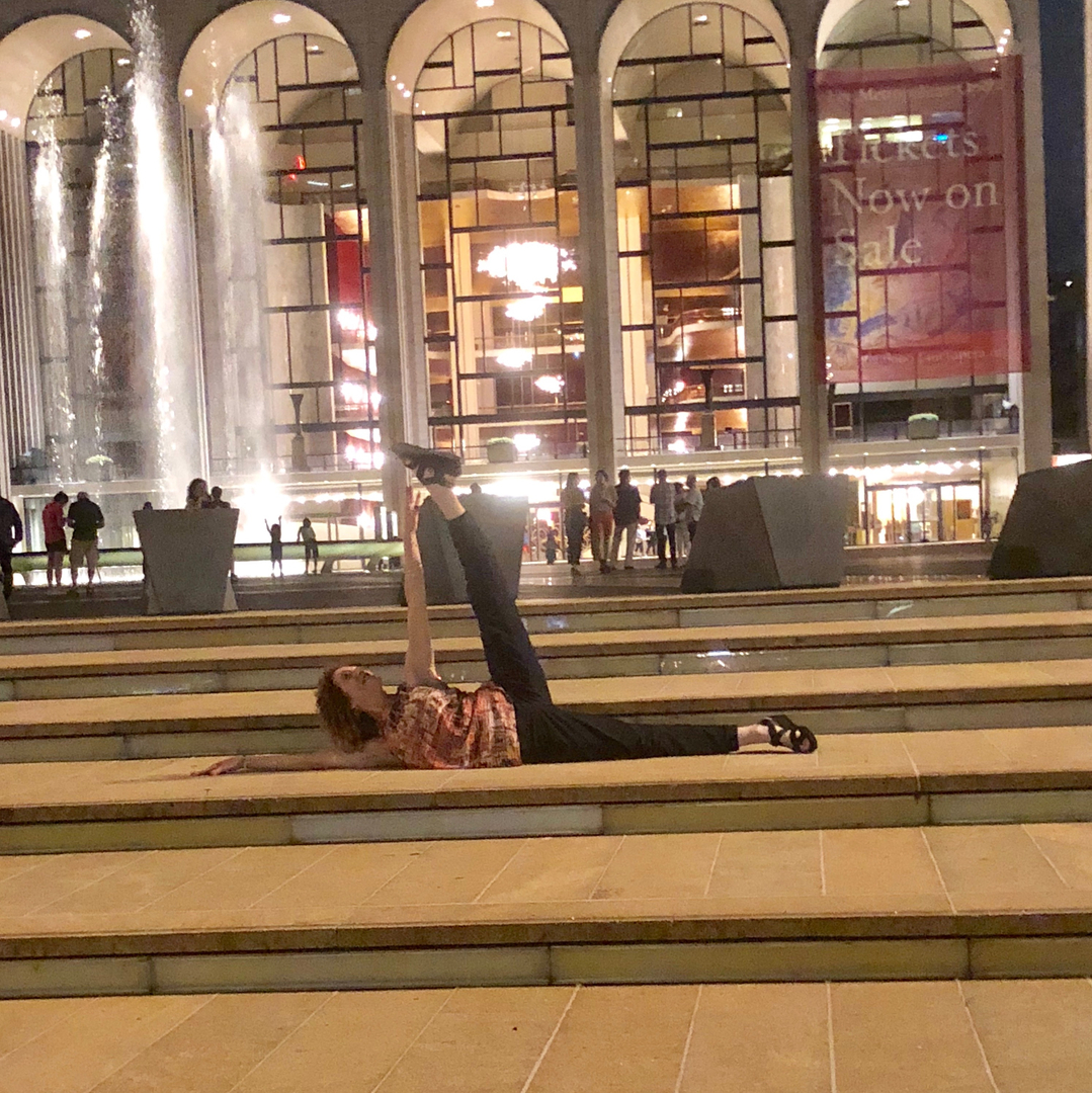 a woman doing the floor-barre exercise outside the Lincoln center