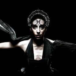A woman with black makeup and wings on her head.