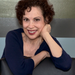 A woman with curly hair sitting on top of a chair.
